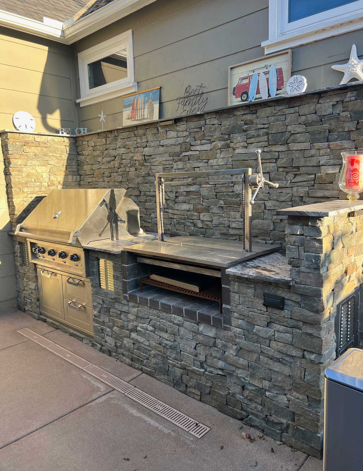 Outdoor kitchen built into a full-height stacked stone wall