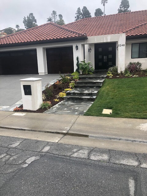 Broad driveway with stone borders fronting a Spanish-style home