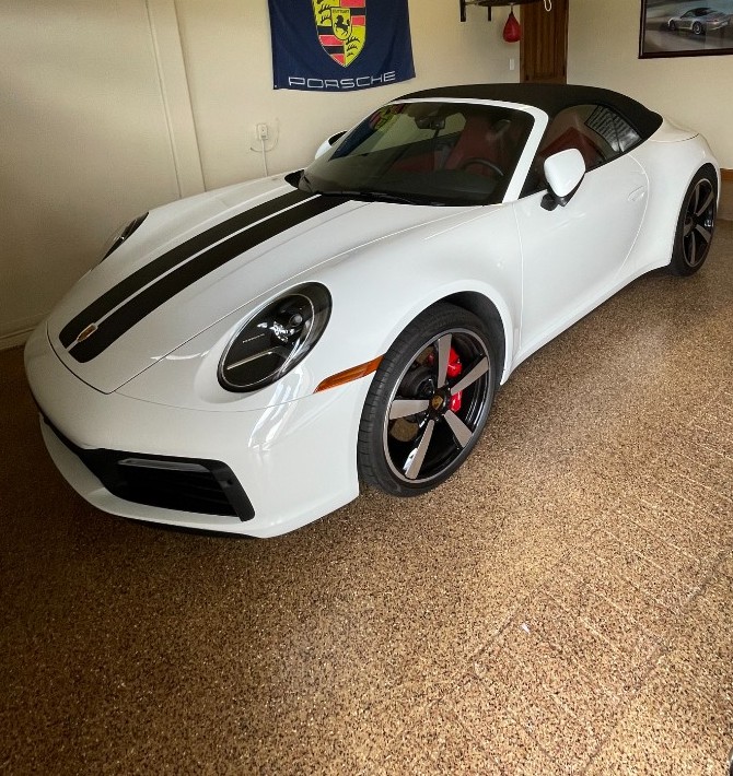 White Porsche parked on a tan and brown flake epoxy garage floor