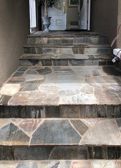Front entry steps faced in natural stone with flagstone treads