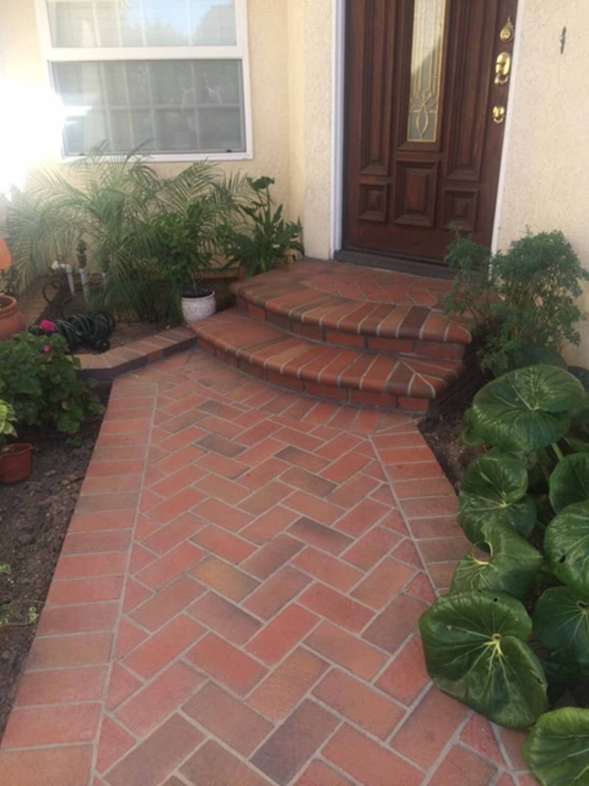 Herringbone brick walkway and brick steps leading to a front door