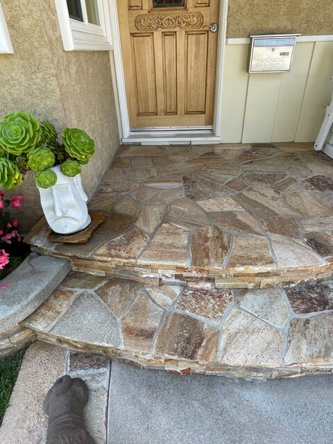 Front porch steps faced in flagstone at a wood front door