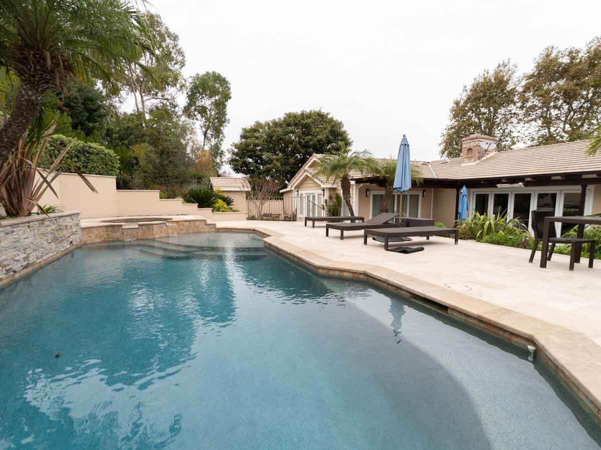 Freeform backyard pool with natural stone surround