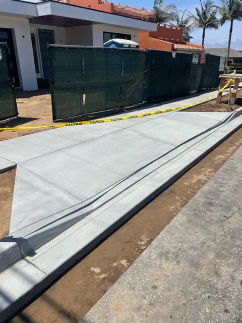 Fresh concrete parkway panels curing behind caution tape