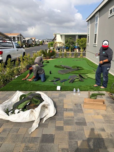 Crew member fitting putting green turf