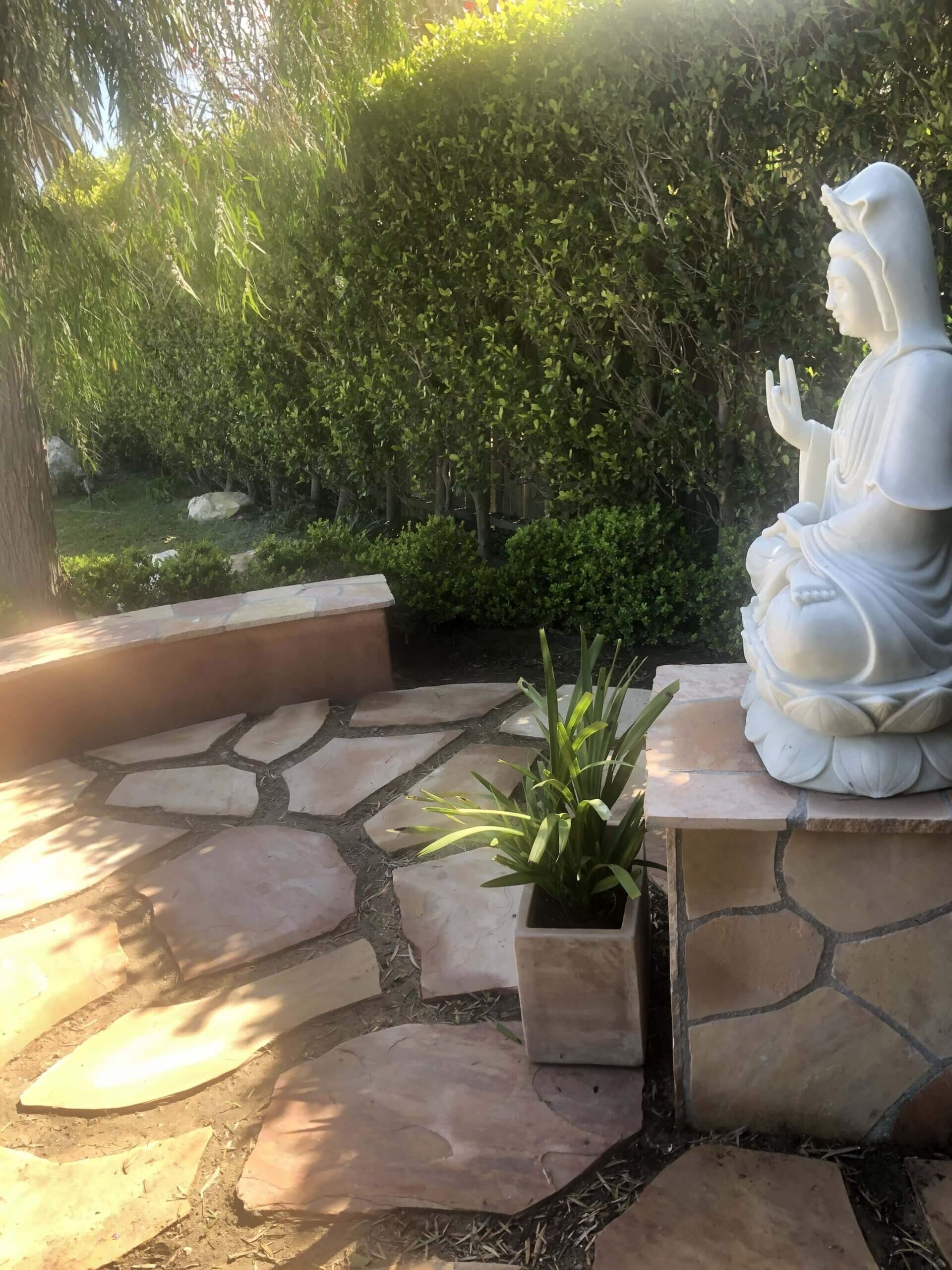 Arizona flagstone steps and seat wall with a stone pedestal and garden statue